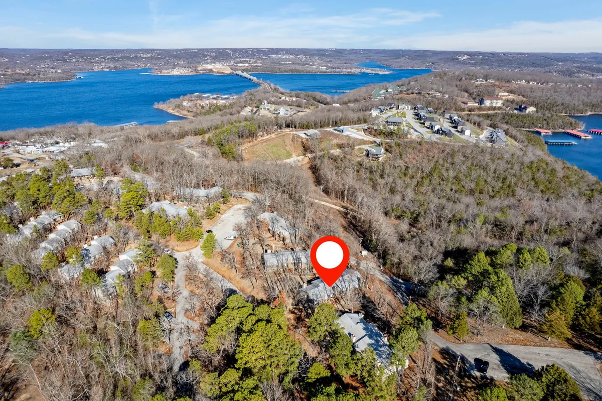 A serene panoramic view of the lake bordered by forested hills and clusters of homes. The scene invites exploration along the shoreline and is rich with natural beauty, hinting at the variety of outdoor adventures available for guests and their pets.