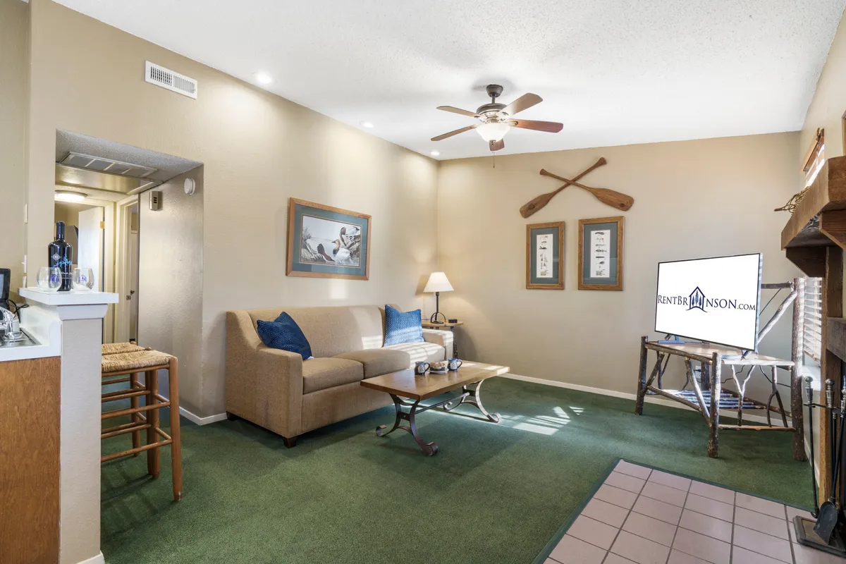 A close-up perspective of a comfortable living room with a plush sofa, coffee table, television, inviting fireplace, and tasteful wall decor. The ambiance is perfect for movie nights or intimate conversations.